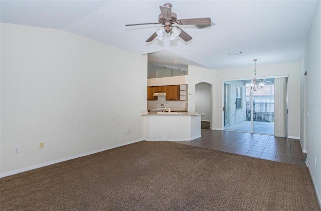 unfurnished living room featuring sink, ceiling fan with notable chandelier, lofted ceiling, and dark tile floors