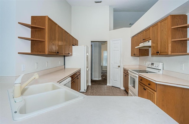 kitchen featuring white appliances, sink, and light tile floors