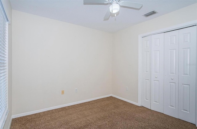 unfurnished bedroom featuring carpet flooring, a closet, and ceiling fan