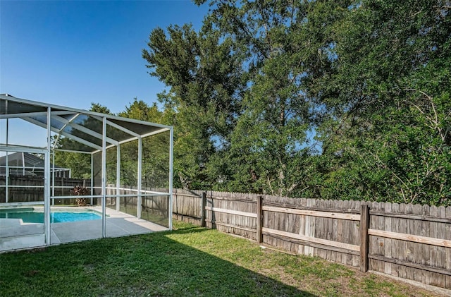 view of yard featuring glass enclosure and a fenced in pool