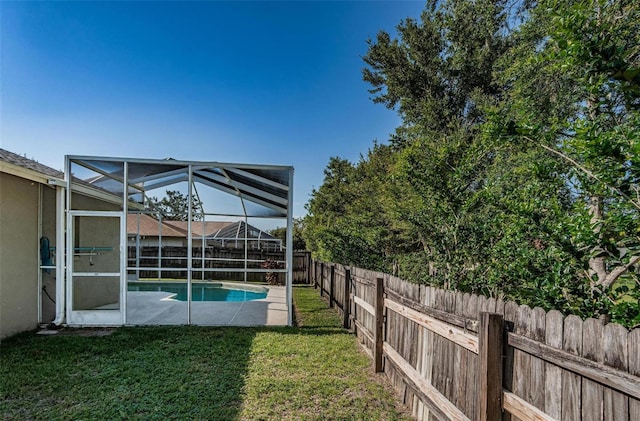 view of yard with glass enclosure and a fenced in pool