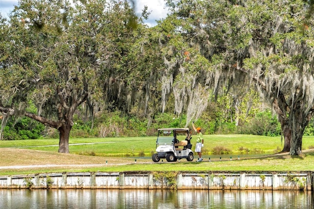 surrounding community with a water view and a yard