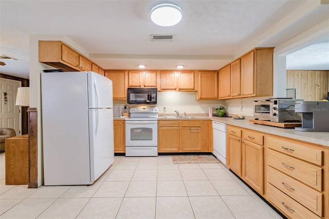 kitchen featuring light brown cabinetry, white appliances, sink, and light tile patterned floors