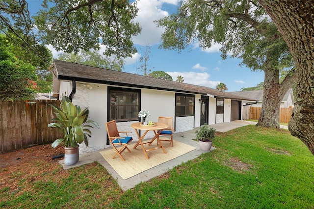 back of property with a patio area and a yard