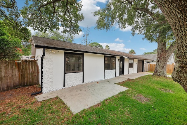 back of house featuring a patio and a lawn