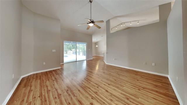 unfurnished room with track lighting, a textured ceiling, ceiling fan, and light wood-type flooring