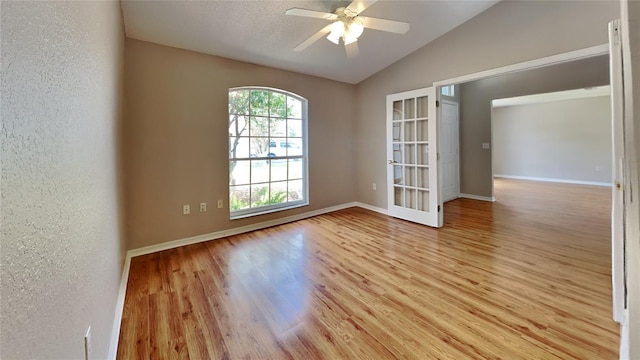 empty room with light hardwood / wood-style floors, lofted ceiling, and plenty of natural light