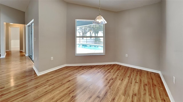 empty room with wood-type flooring and vaulted ceiling