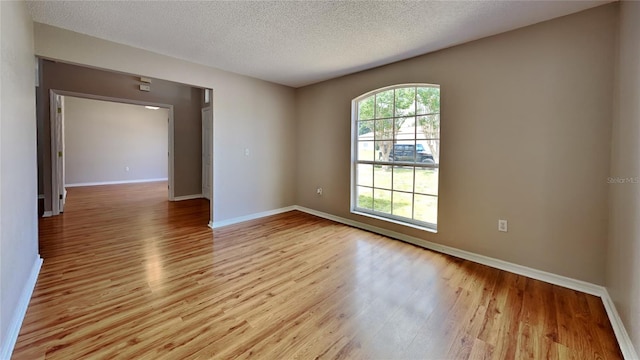 unfurnished room featuring hardwood / wood-style floors and a textured ceiling