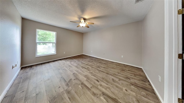 empty room featuring a textured ceiling, wood-type flooring, and ceiling fan