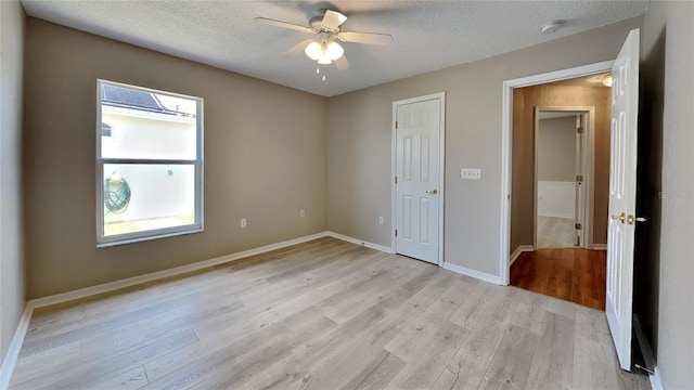 unfurnished bedroom with ceiling fan, light hardwood / wood-style flooring, and a textured ceiling