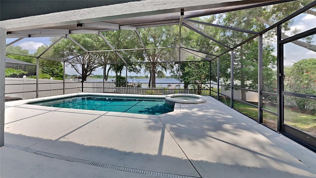 view of pool featuring a patio area, glass enclosure, and an in ground hot tub