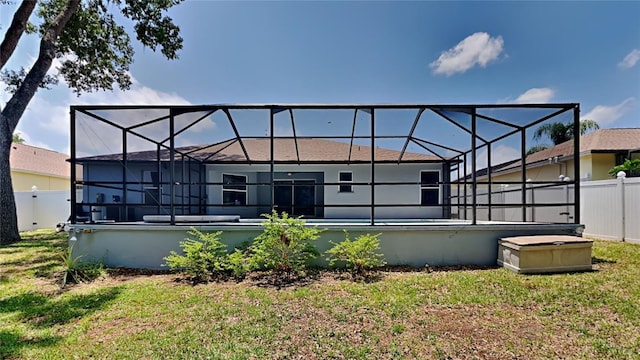 back of property featuring a lawn and a lanai