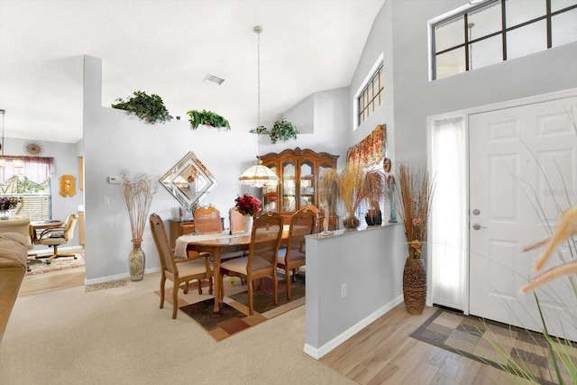 carpeted foyer entrance featuring high vaulted ceiling