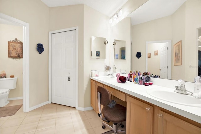 bathroom featuring dual vanity, tile floors, and toilet