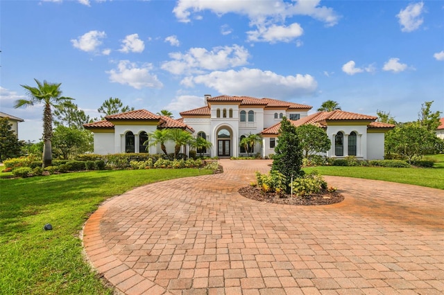 mediterranean / spanish house with a front lawn