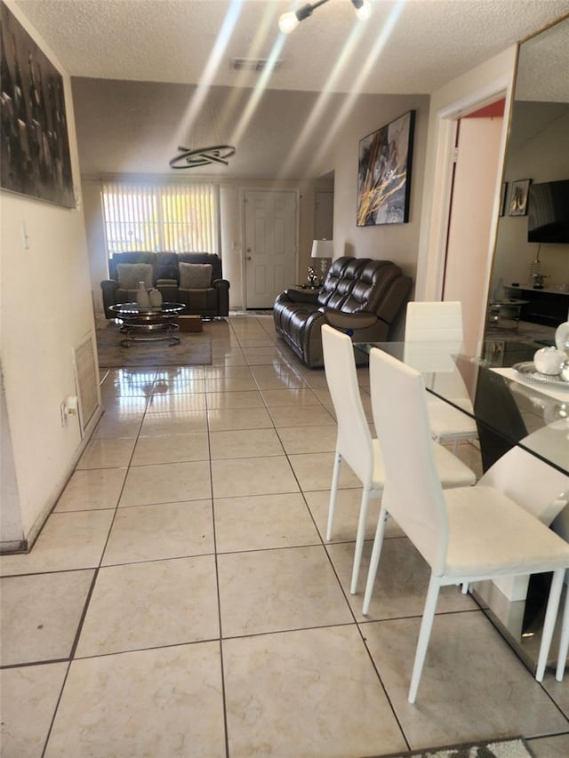 tiled dining area with a textured ceiling