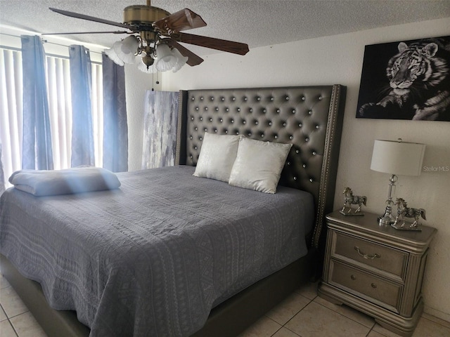 bedroom featuring multiple windows, a textured ceiling, ceiling fan, and light tile floors