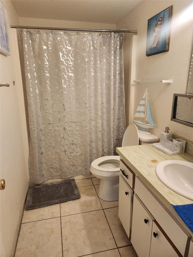 bathroom featuring tile floors, toilet, and vanity