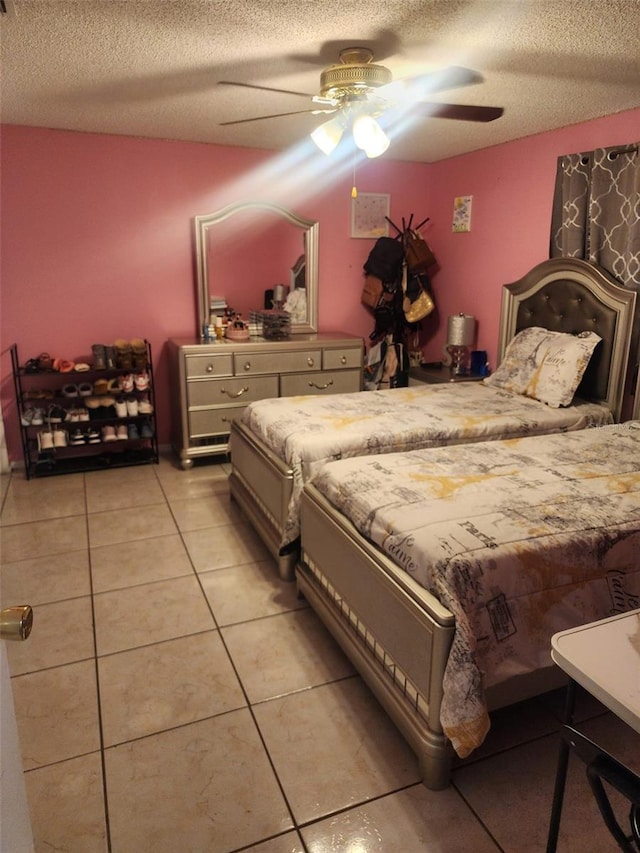 bedroom featuring a textured ceiling, ceiling fan, and light tile flooring