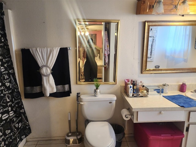 bathroom with tile flooring, vanity, and toilet