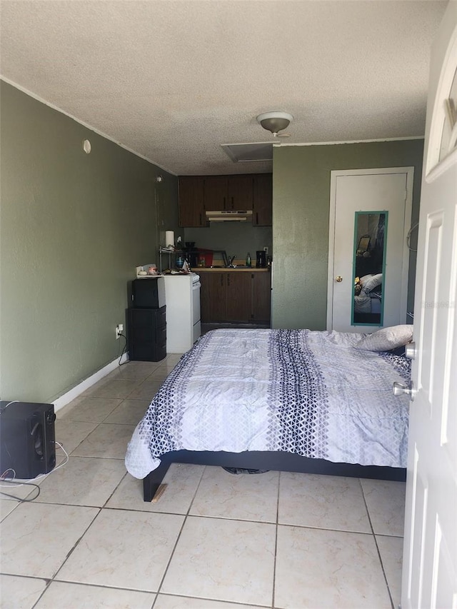 tiled bedroom featuring sink, a textured ceiling, and washer / clothes dryer