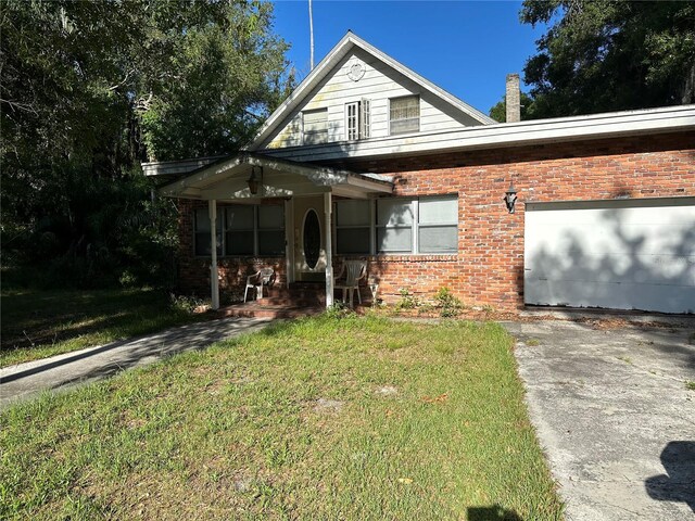 bungalow featuring a garage and a front lawn