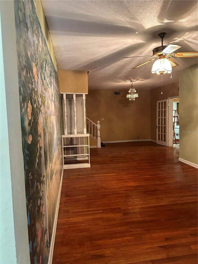 unfurnished room featuring a textured ceiling, ceiling fan, and dark hardwood / wood-style floors