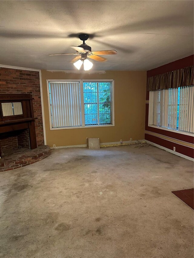 unfurnished living room featuring brick wall, a textured ceiling, carpet flooring, and ceiling fan