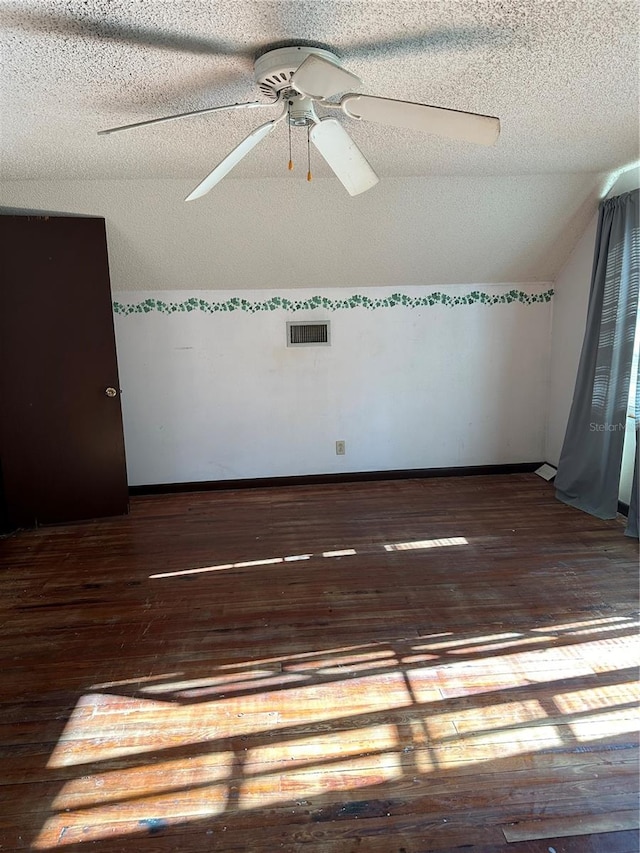 unfurnished room with a textured ceiling, ceiling fan, and dark hardwood / wood-style floors