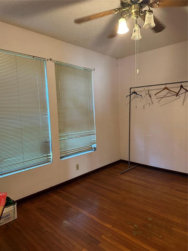 spare room featuring a textured ceiling, dark hardwood / wood-style floors, and ceiling fan