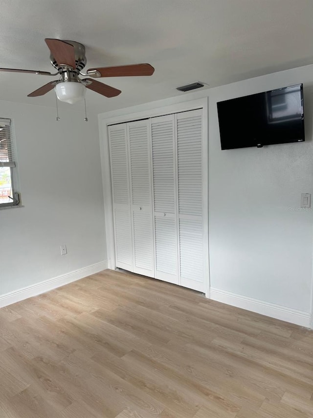 unfurnished bedroom featuring ceiling fan, a closet, and light hardwood / wood-style floors