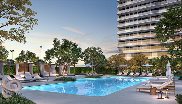 pool at dusk featuring a patio