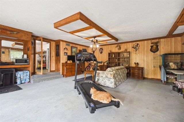 exercise room with wood walls and a ceiling fan