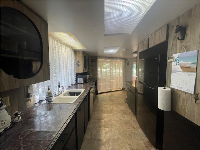 kitchen with freestanding refrigerator, a sink, and stainless steel dishwasher