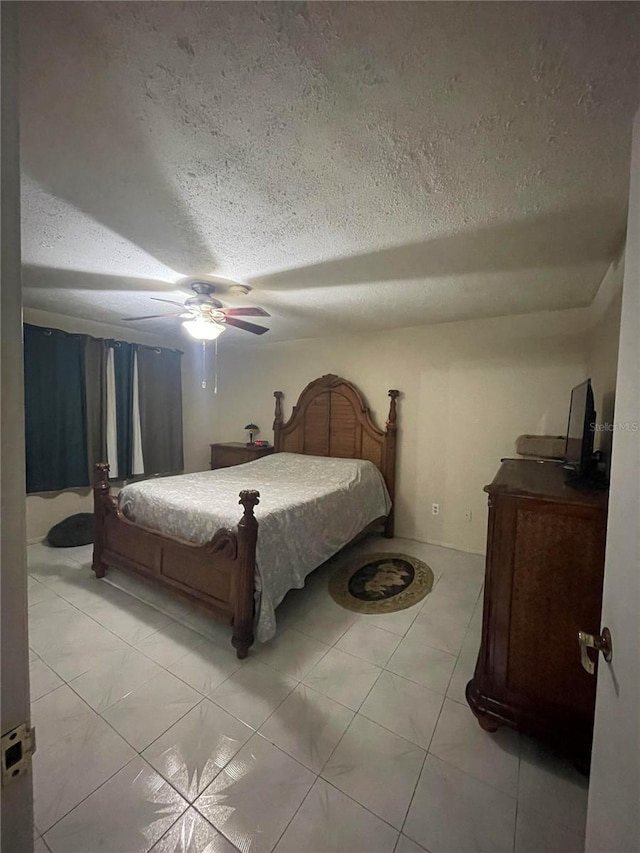 bedroom featuring ceiling fan, a textured ceiling, and light tile patterned flooring