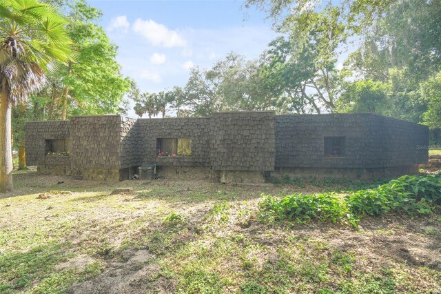 exterior space featuring mansard roof and roof with shingles