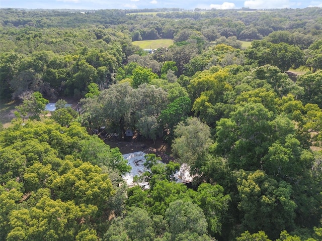 drone / aerial view featuring a wooded view