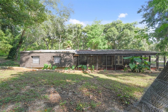 exterior space featuring metal roof and a front yard