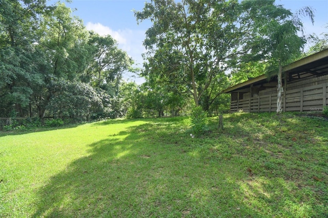 view of yard featuring an outbuilding and fence