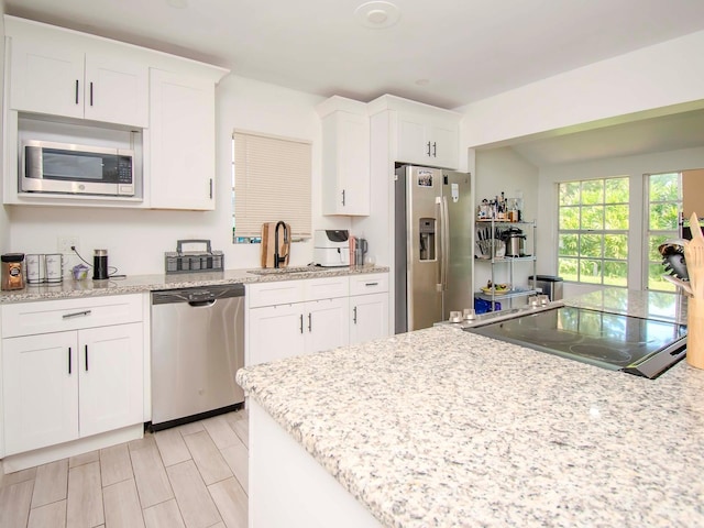 kitchen featuring sink, white cabinets, light stone counters, and stainless steel appliances