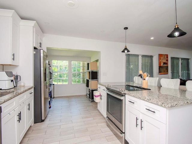 kitchen with light stone counters, light tile floors, hanging light fixtures, white cabinetry, and appliances with stainless steel finishes