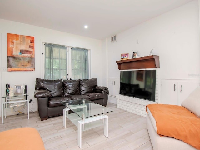 living room with a fireplace and light wood-type flooring