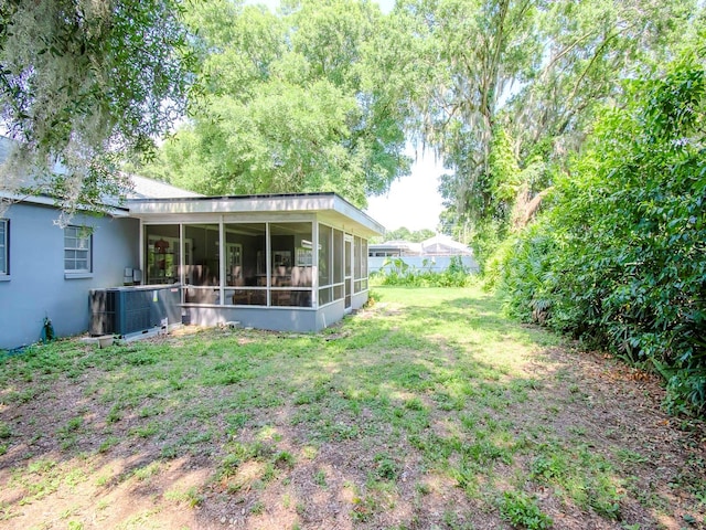 view of yard featuring a sunroom and central AC unit