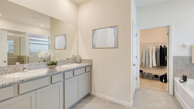 bathroom featuring dual sinks, tile flooring, oversized vanity, and plus walk in shower