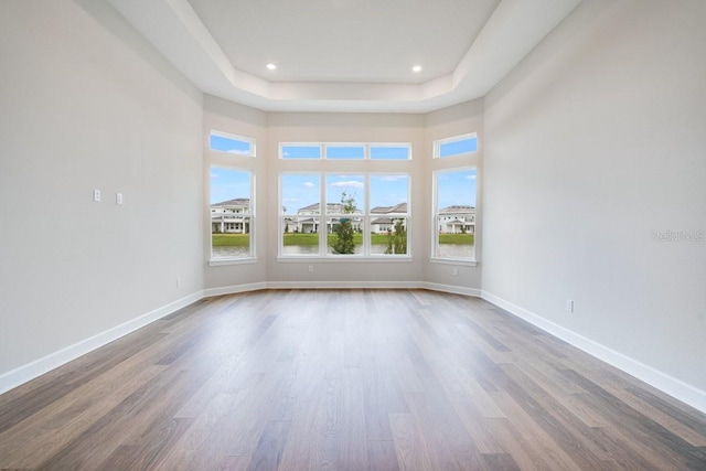 empty room featuring recessed lighting, wood finished floors, and baseboards