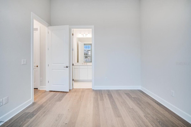 spare room featuring baseboards and light wood finished floors