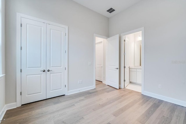 unfurnished bedroom with visible vents, light wood-style flooring, and baseboards