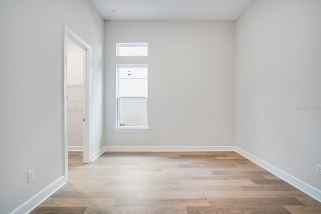 spare room featuring baseboards and wood finished floors