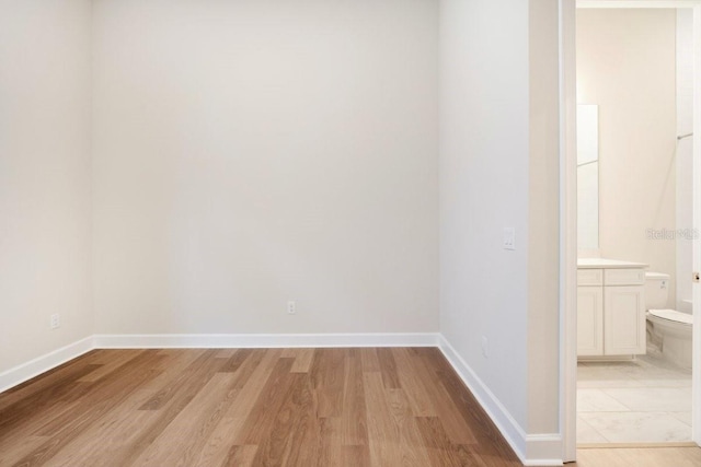 empty room with baseboards and light wood-type flooring